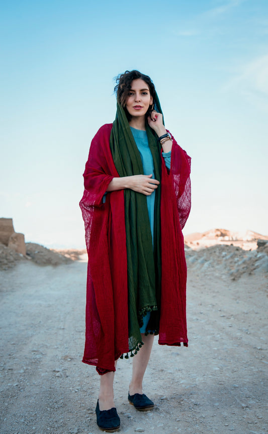 woman in red hijab standing on brown sand during daytime