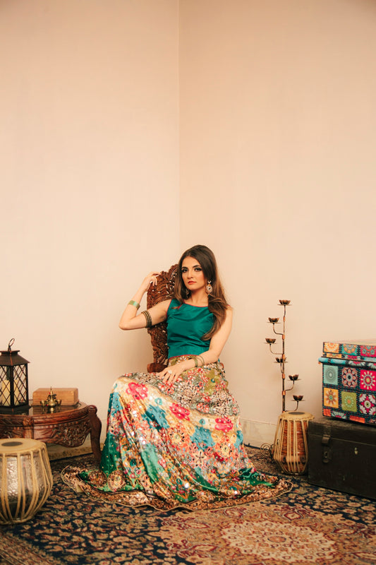 woman in green and pink floral dress sitting on brown wooden chair