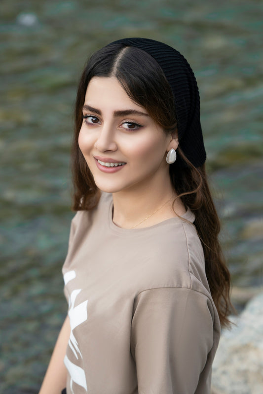 woman in white crew neck shirt and black knit cap smiling