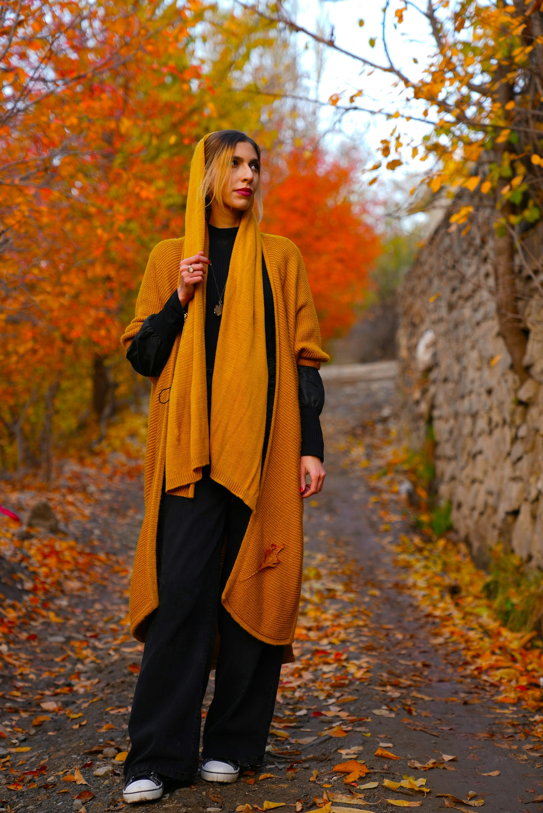 a woman standing on a path in the fall