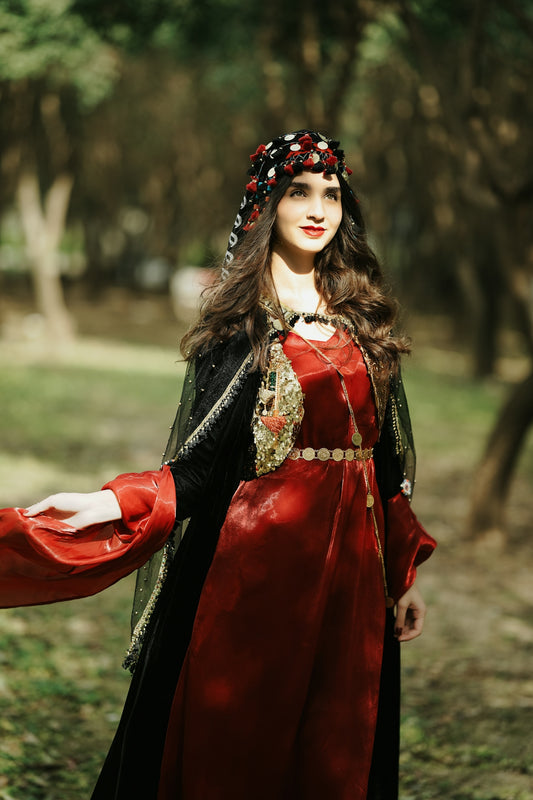 a woman in a red dress is standing in the woods