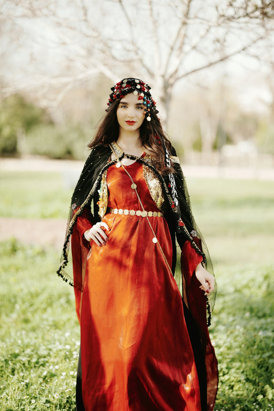a woman in a red dress is standing in the grass