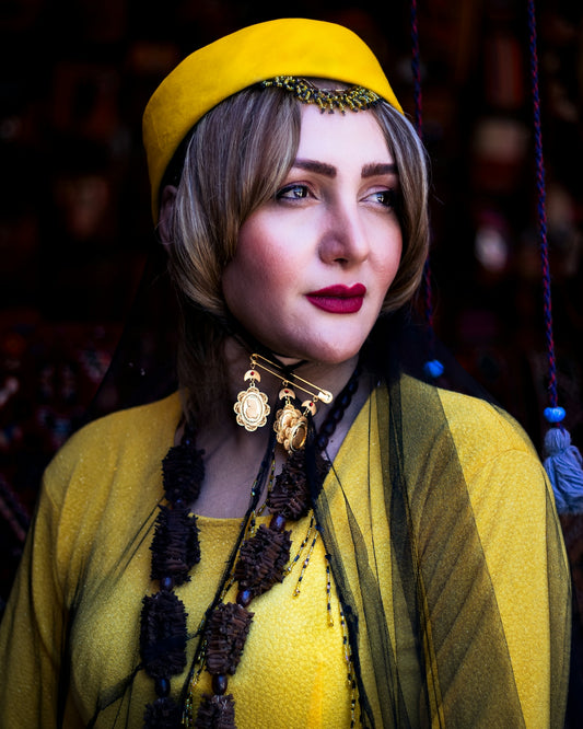 A woman wearing a yellow hat and a necklace