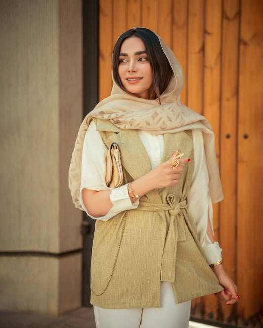 A woman in white pants and a tan jacket