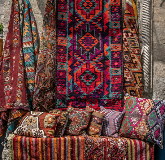 Beautiful, colorful rugs and pillows for sale.